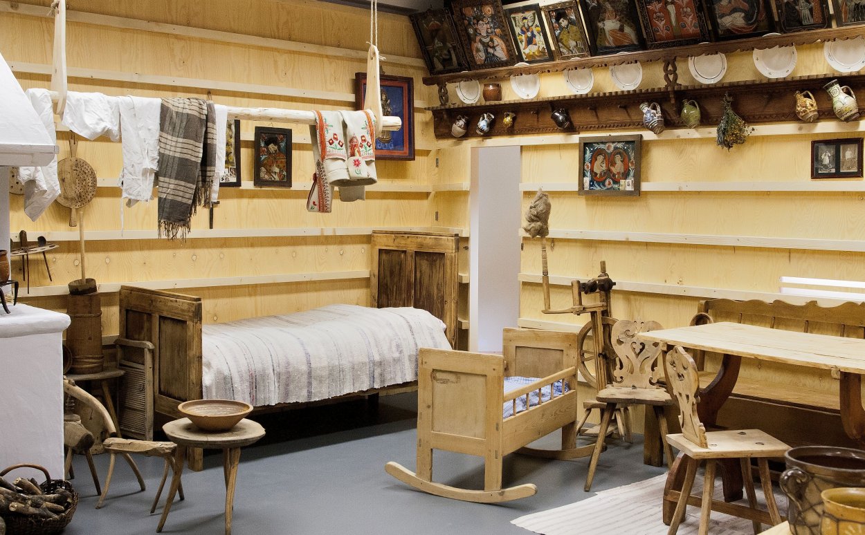 Museum hall - stove, bed, cradle, shelves on the walls