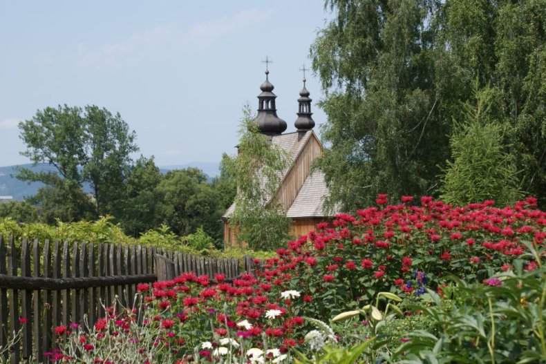 Church towers in the distance, a flower garden in front.